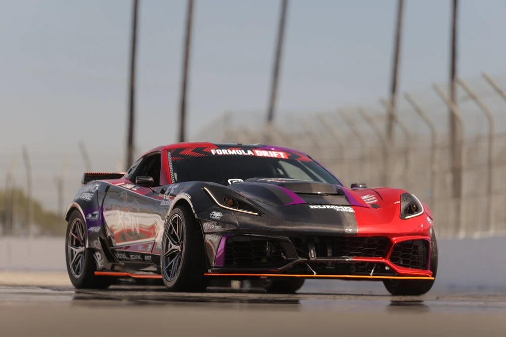 Corvette rouge et noire sur un circuit, avec phares C7 TLO.
